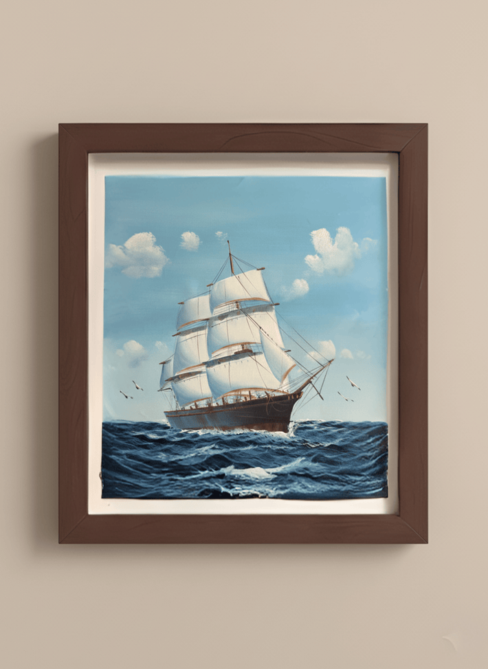 Framed artwork of a sailboat on a blue sky and ocean background
