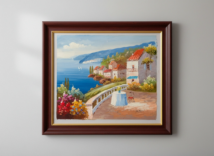 Framed painting of a coastal scene with houses and flowers on a gray wall