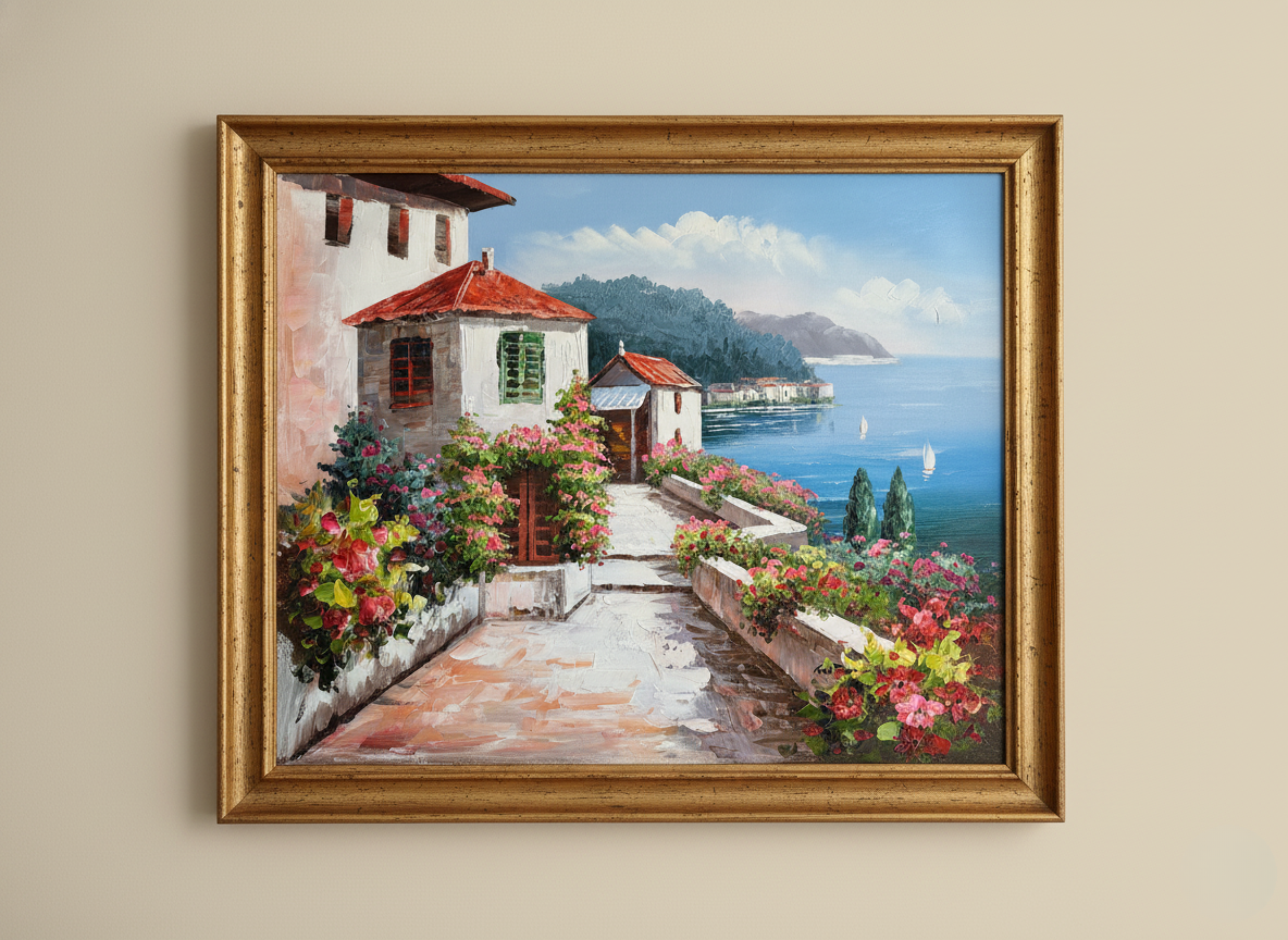 Framed painting of a coastal scene with houses and flowers on a beige wall.