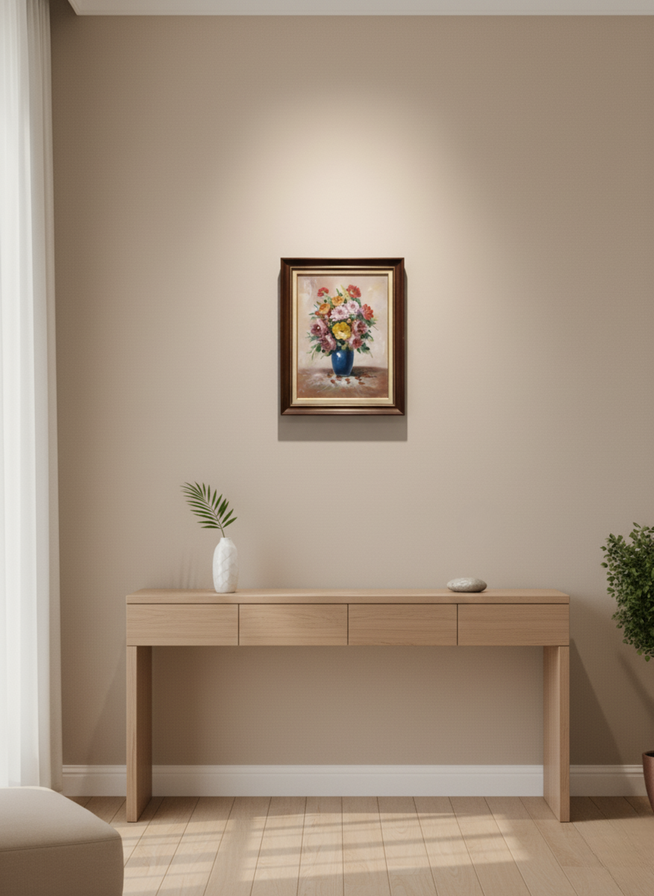 Beige wall with a framed painting above a wooden desk.
