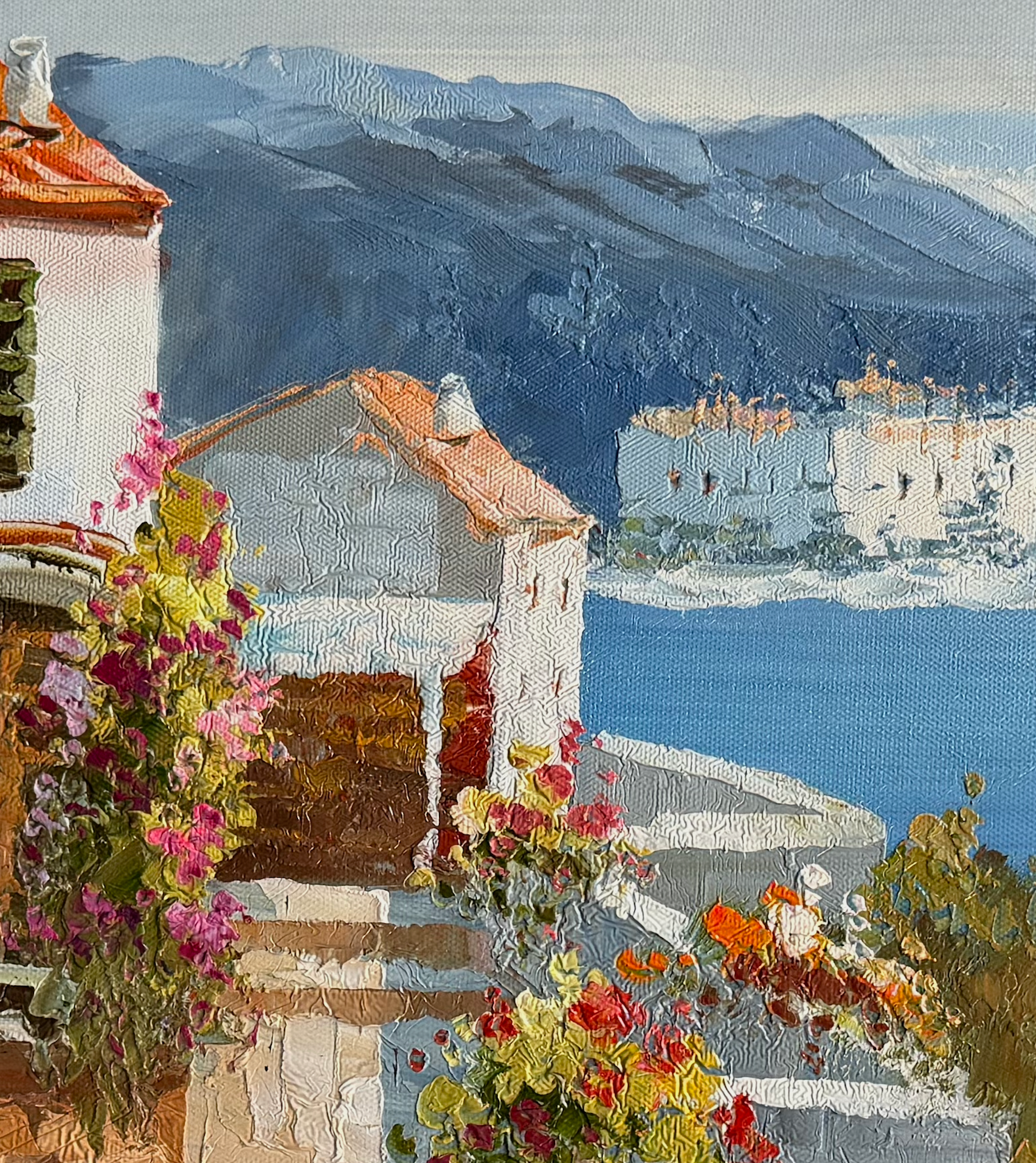 Painting of a Mediterranean village with flowers and mountains in the background