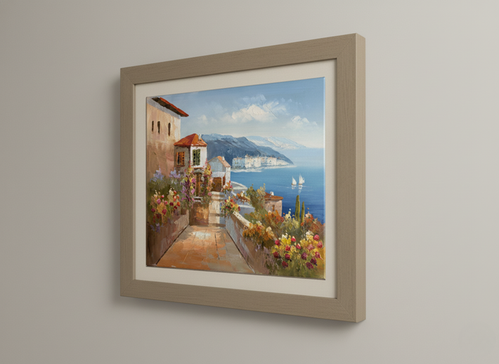 Framed painting of a coastal scene with a house and ocean view on a wall.