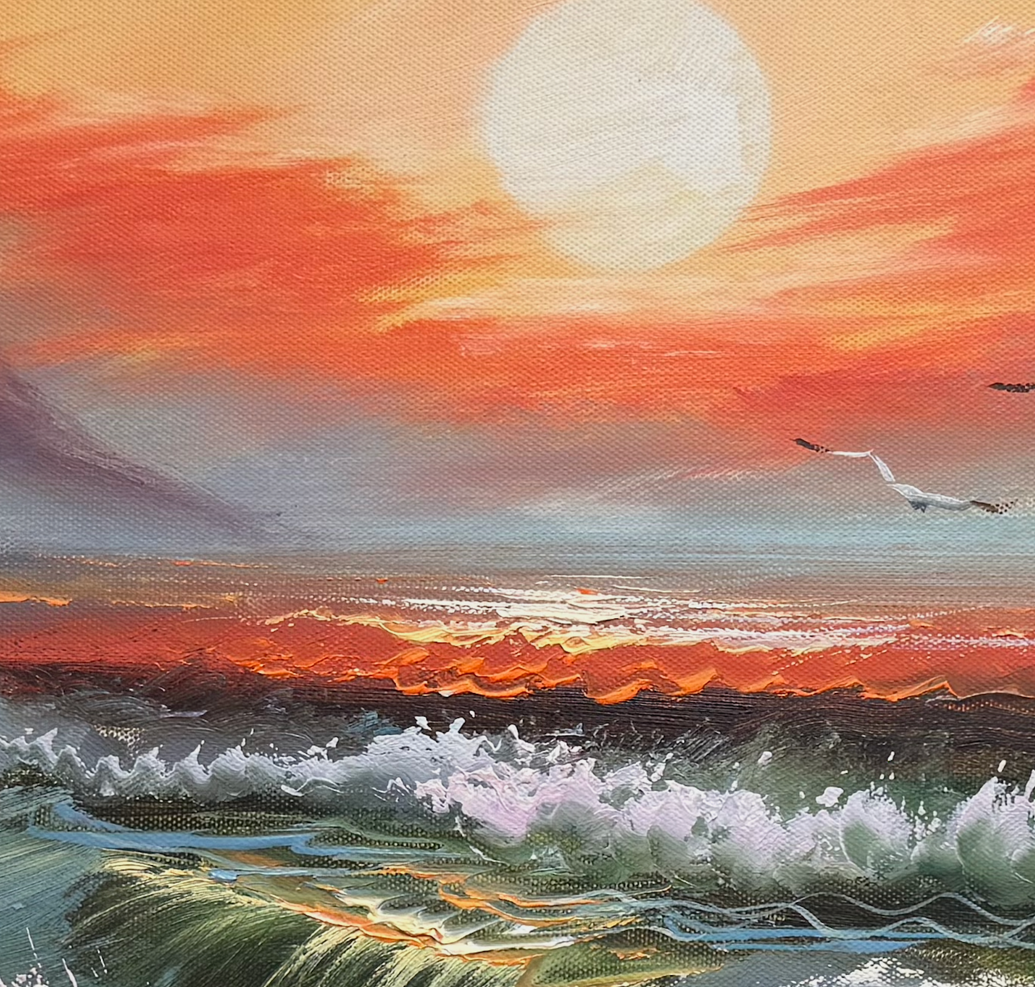 Sunset over the ocean with a large moon in the sky